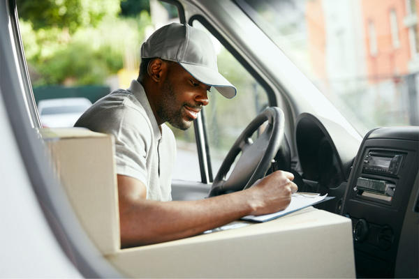 elivery Man Reading Addresses Sitting In Delivery Van